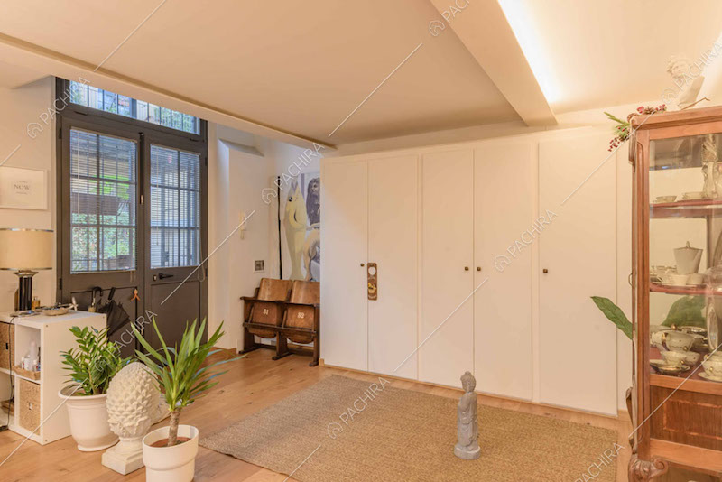 Pavimento in parquet, porta in stile industriale e armadio a muro bianco