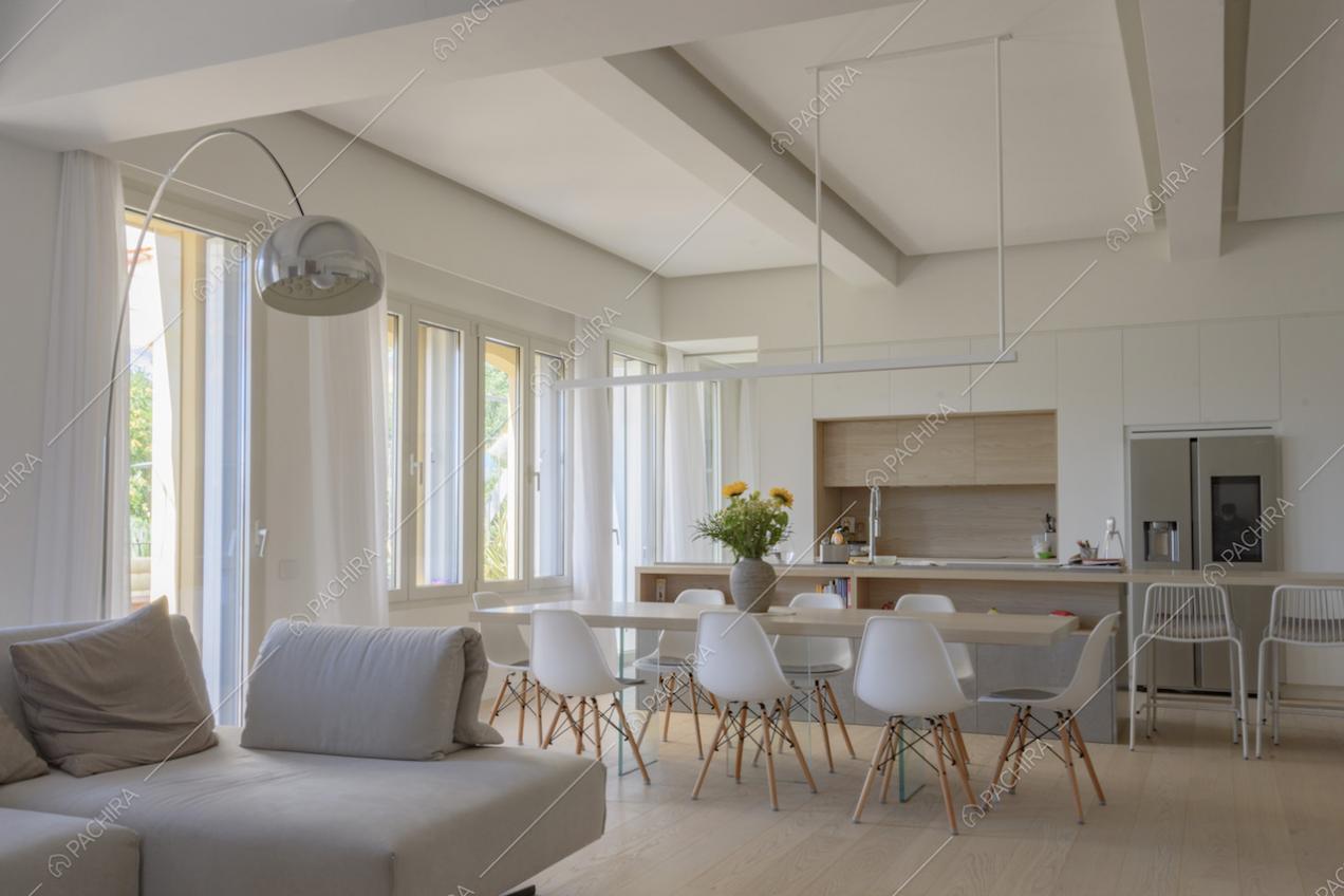 Grandi finestre lungo un lato della zona giorno e arredi di design
