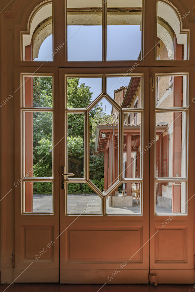 Porta finestra bianca con fantasia geometrica per accedere al cortile d'ingresso