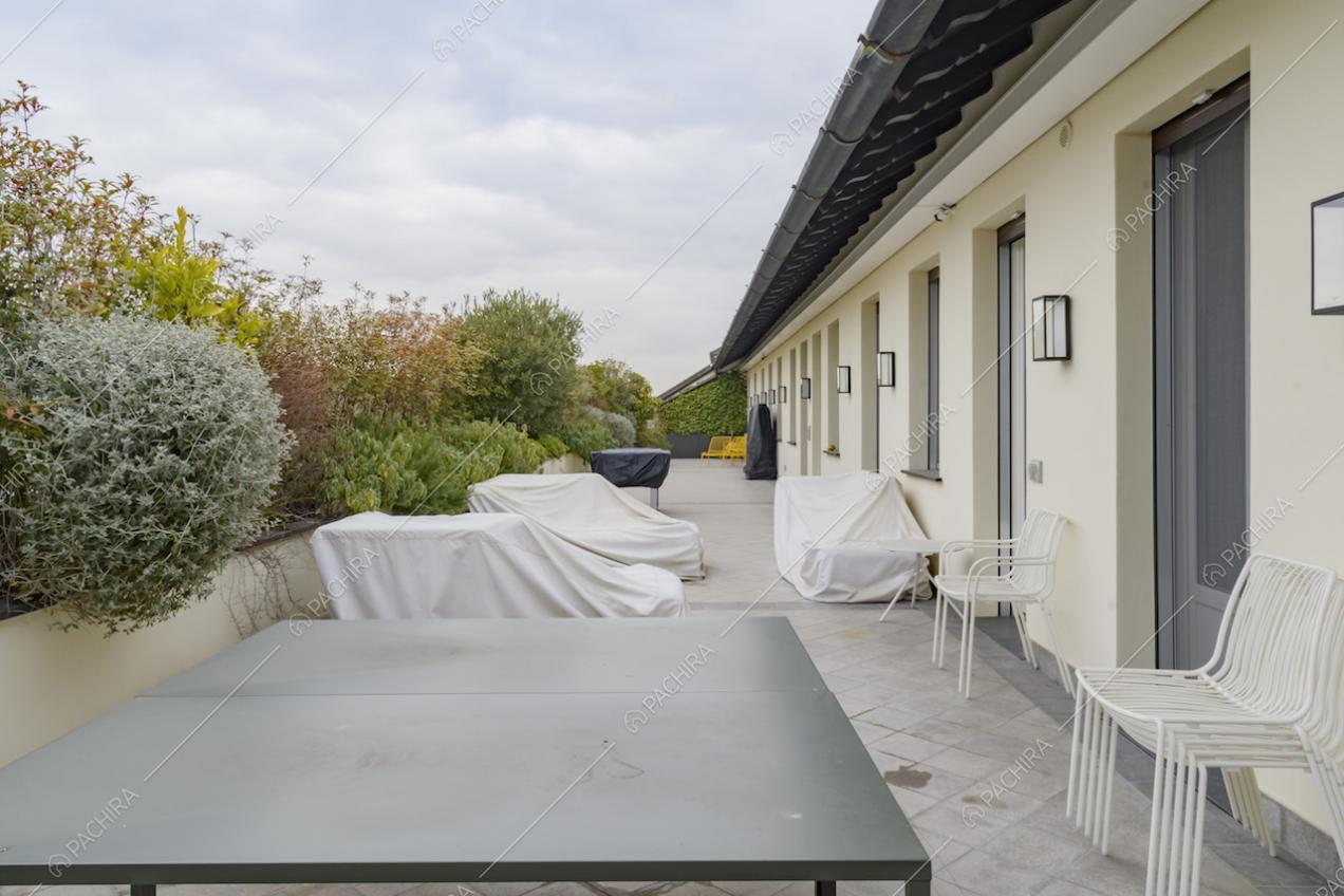 Tavolo da esterni nero e sedie sulla terrazza con piante