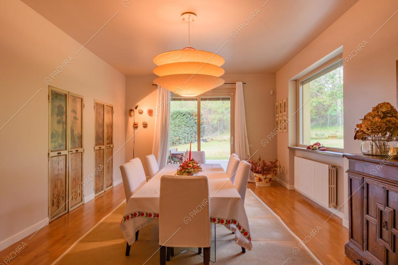 Sala da pranzo con vista sul giardino tramite le vetrate e pavimento in parquet