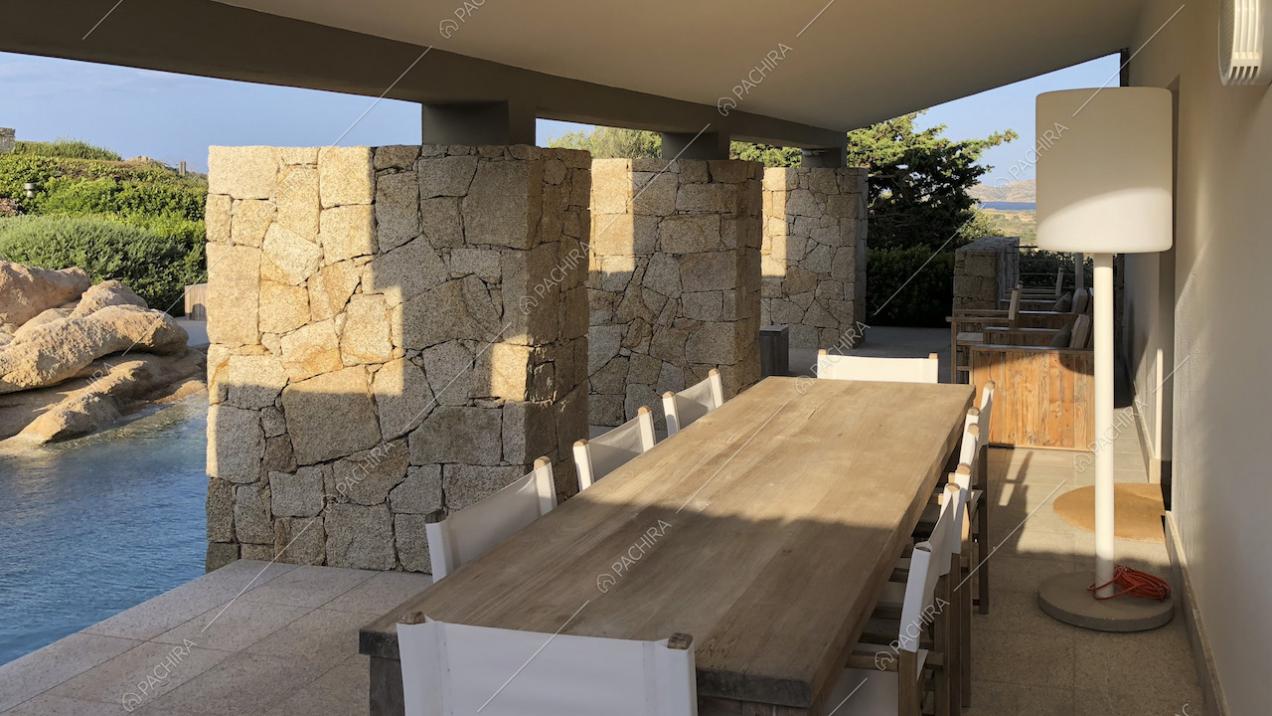 Tavolo da pranzo rettangolare in legno e lampada a bordo piscina
