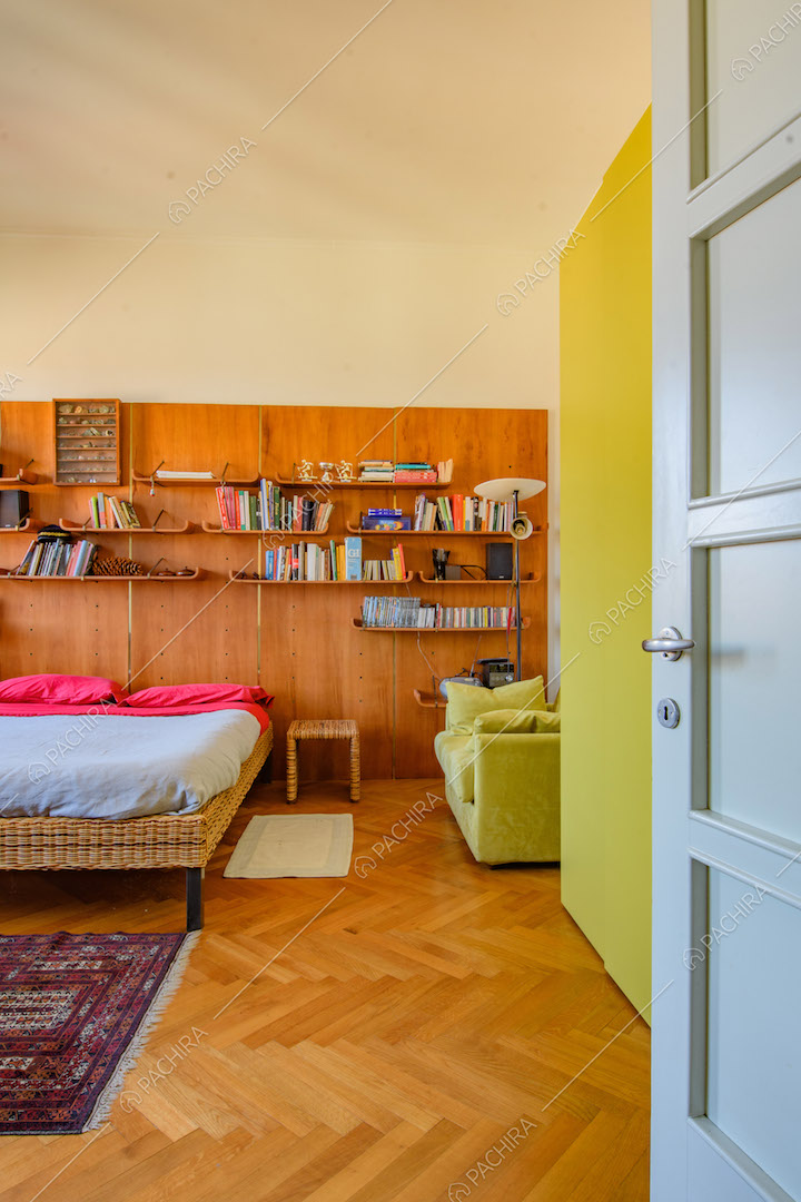 Pavimento in parquet a spina di pesce e parete in legno nella camera da letto matrimoniale