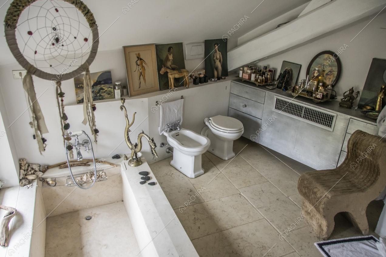 Bagno in stile vintage con vasca, ritratti e soprammobili