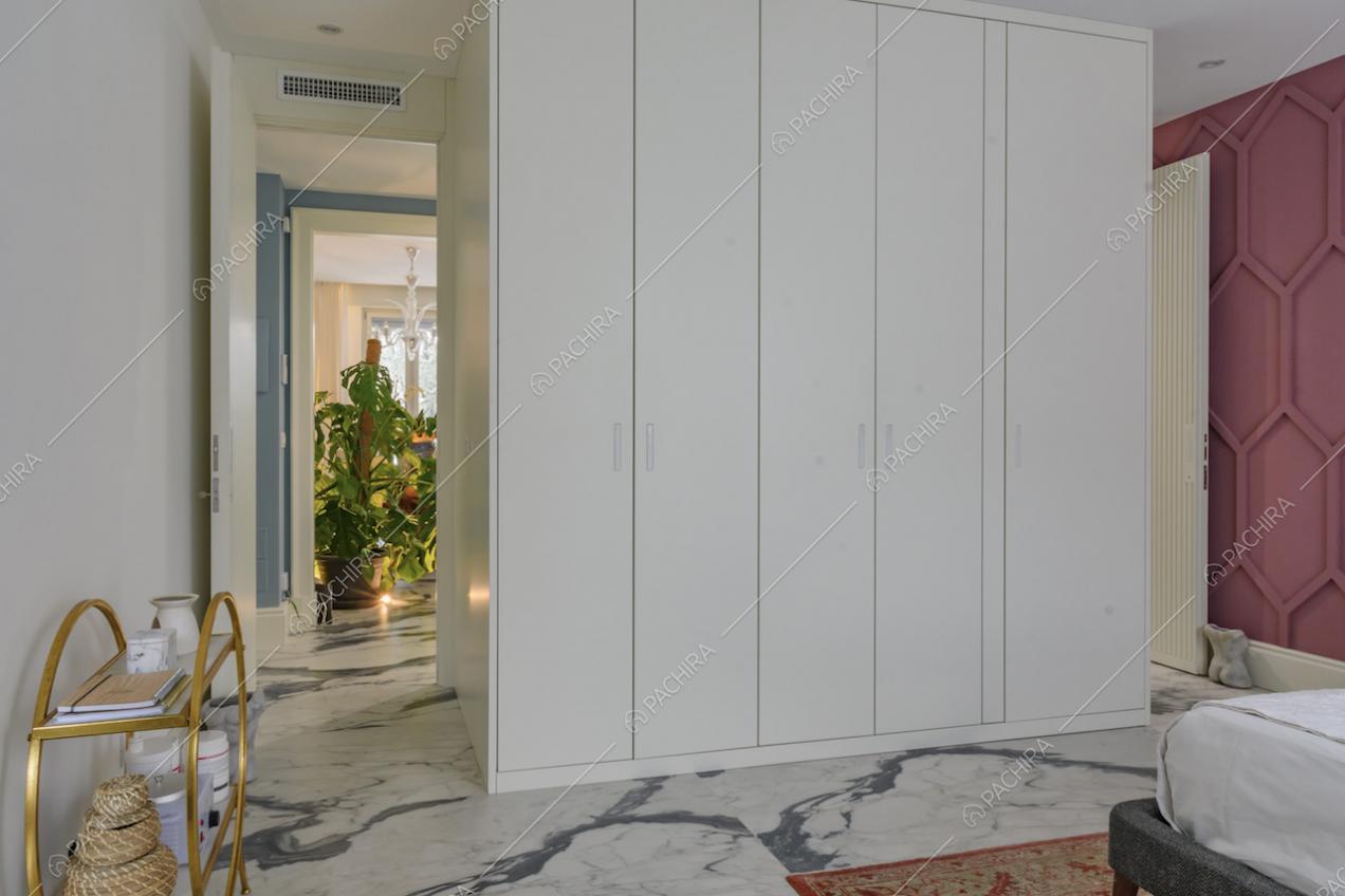 Nella camera da letto matrimoniale, ampio armadio bianco e scorcio sulle piante del salotto