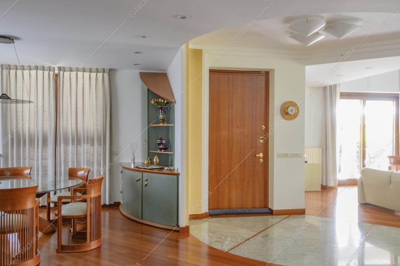 Ingresso della location, tavolo da pranzo e scorcio sul salotto