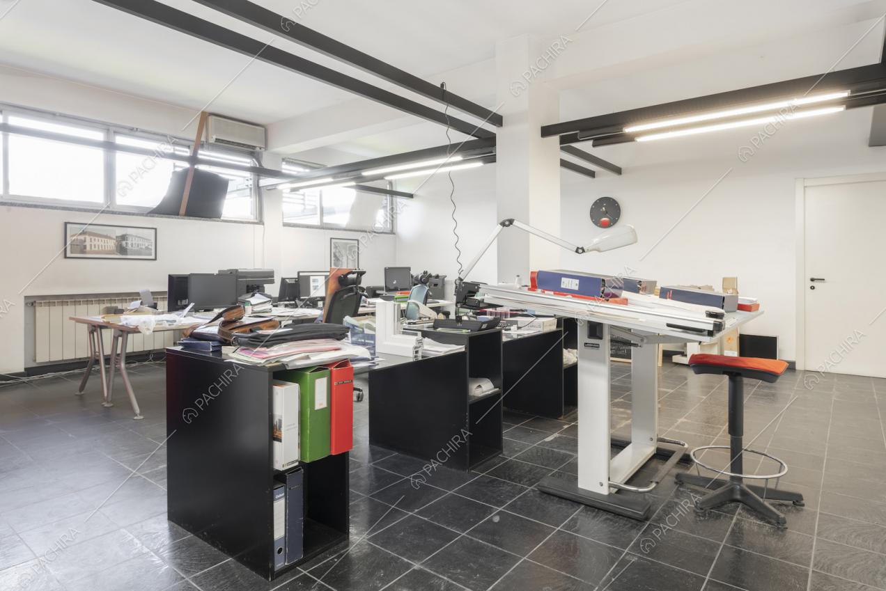 Ufficio con tavoli, scaffali e luci al neon al piano terra 