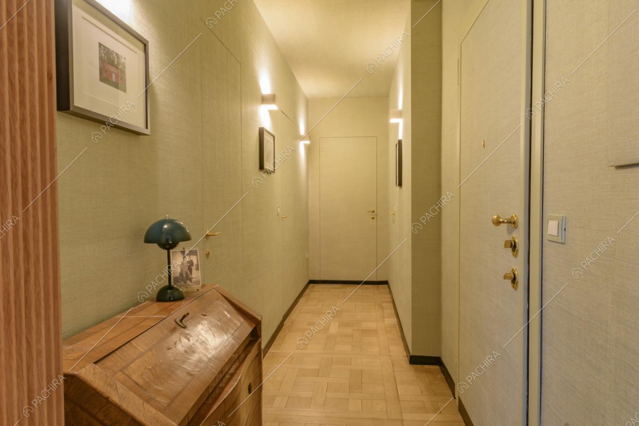 Corridoio con pavimento in parquet e pareti con carta da parati 