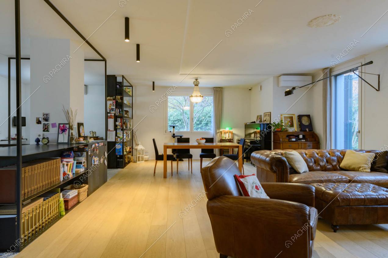Grande sala con pavimento in parquet, divano e poltrone in pelle marrone vintage
