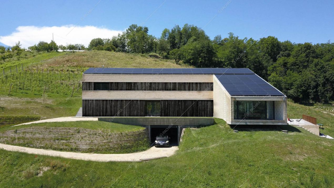 Vista sulla location immersa nel verde con garage e pannelli solari sul tetto