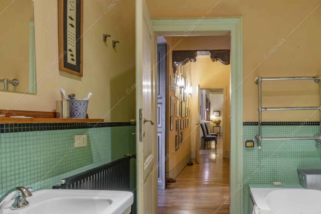 Bagno con parete color pastello e piastrelline in ceramica