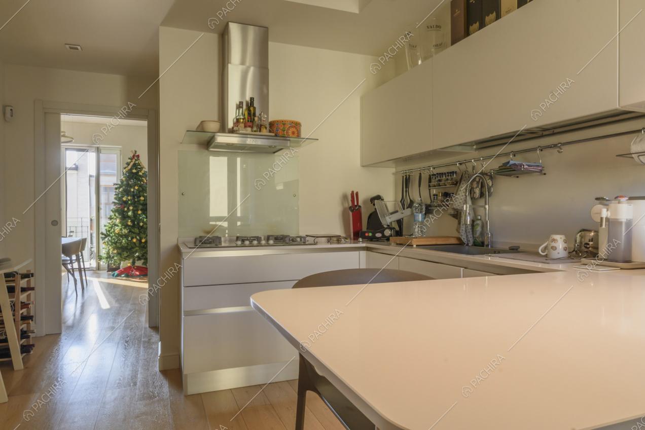 Cucina con bancone e sgabelli bianchi