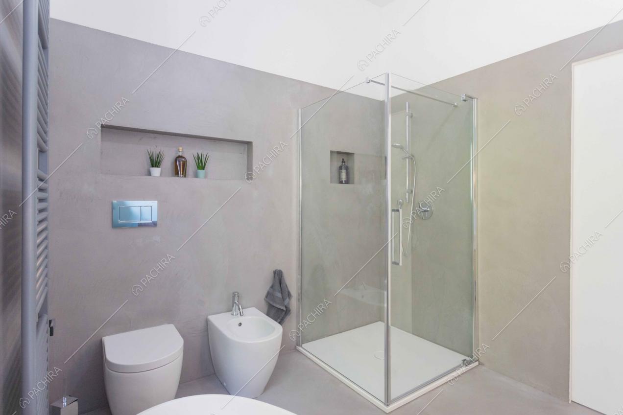 Bagno con pavimento e pareti grigie e box doccia