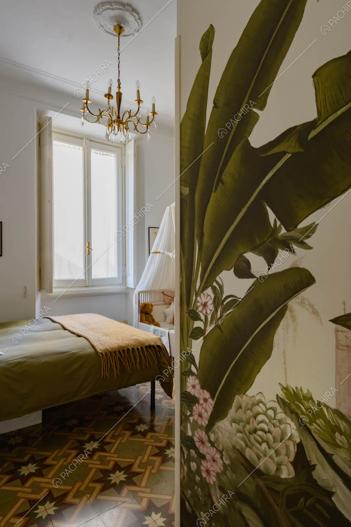 Carta da parati a tema tropicale nella camera da letto matrimoniale con pareti bianche