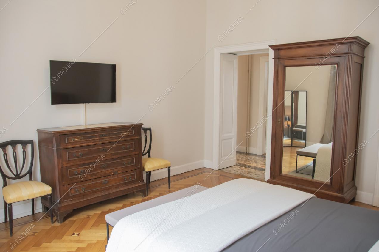 Cassettiera in legno, sedie in stile antico e televisione