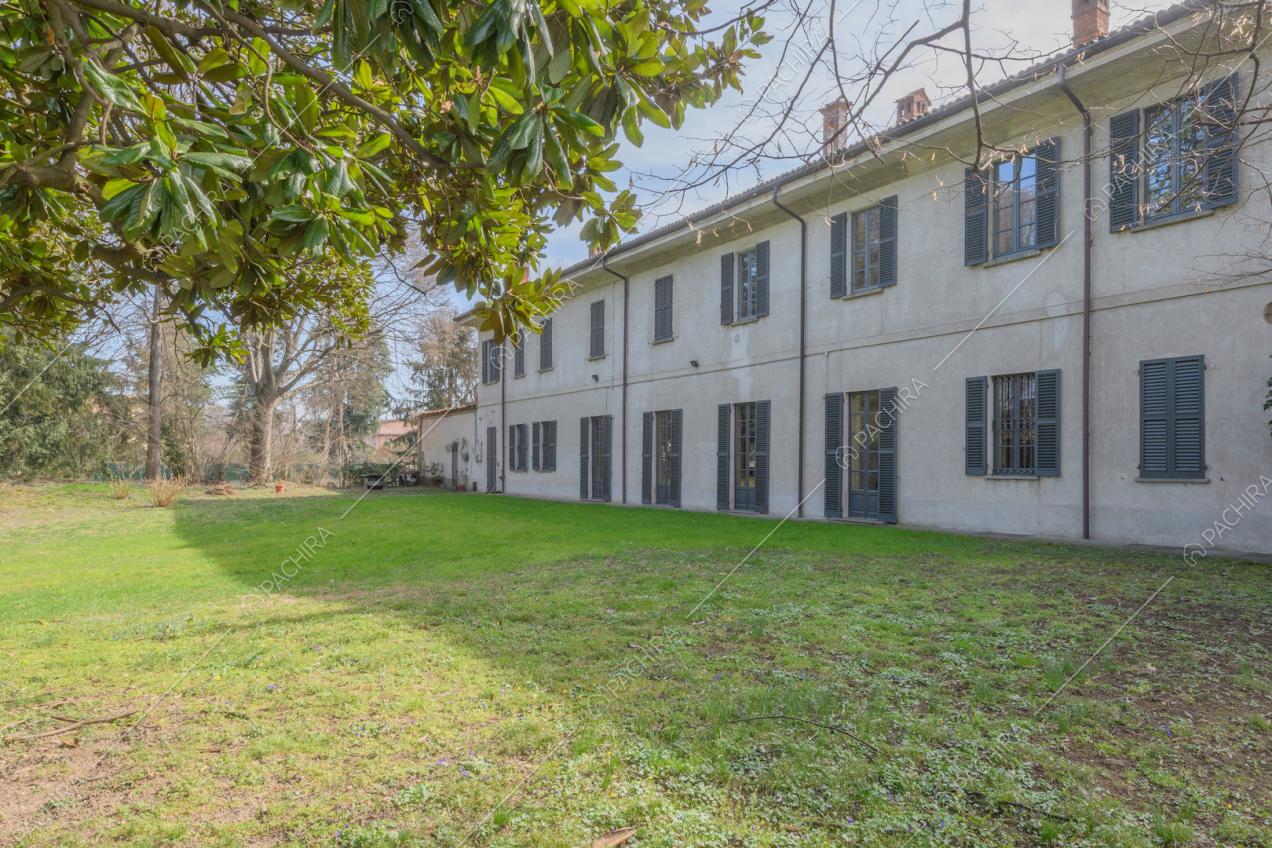 Giardino della dimora storica con vista sugli esterni bianchi con persiane