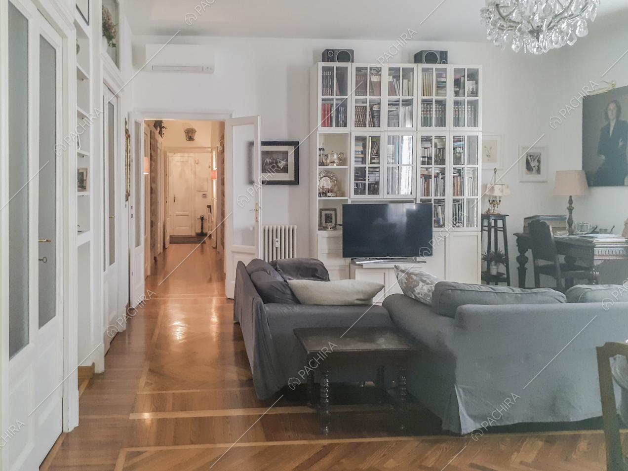 Arredi antichi, libreria, divani e parquet nel salotto
