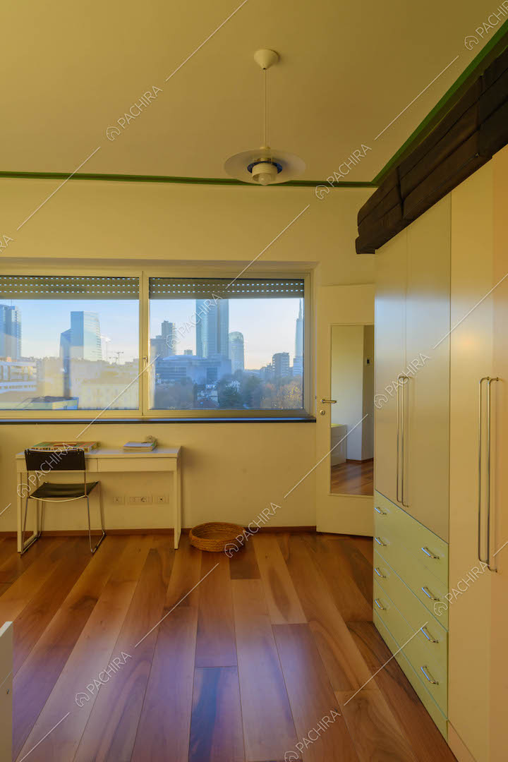 Pavimento in parquet e finestre con vista sullo skyline nella camera da letto
