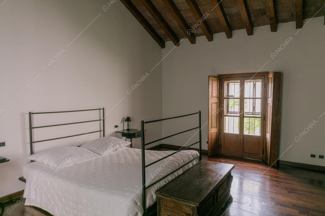 Camera da letto con parquet e travi a vista
