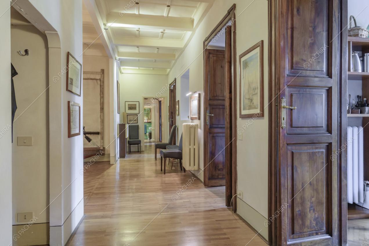 Porte in legno e quadri lungo le pareti del corridoio