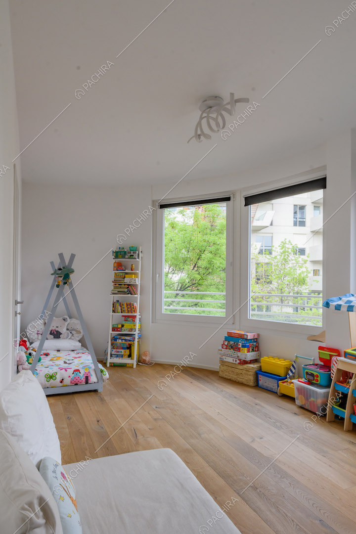 Camera dei bambini con pavimento in parquet e vetrate