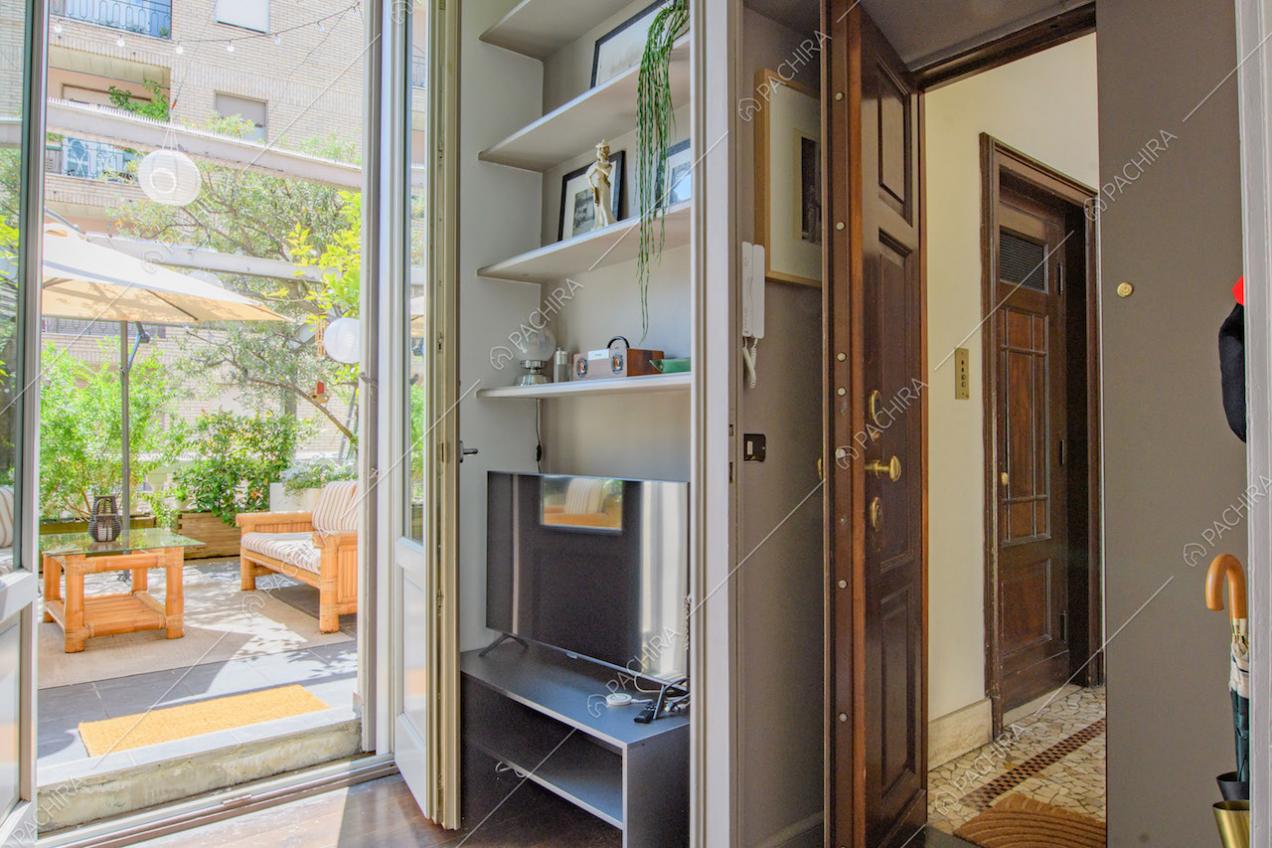 Parete grigia della porta d'ingresso e accesso alla terrazza tramite porta-finestra