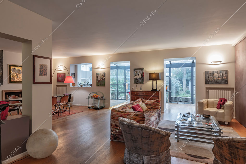 Zona living con vista sulle vetrate della cucina dell'appartamento Catalpa, location in stile moderno a Roma