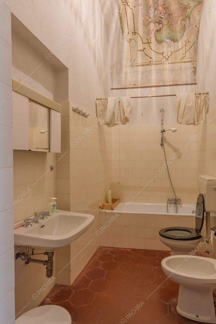 Pavimento in cementine rosse nel bagno con vasca e soffitto affrescato