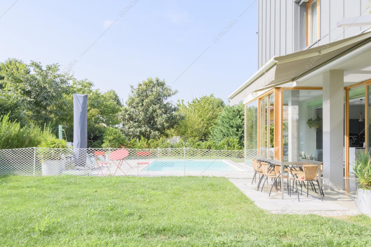 Veranda con tavolo da pranzo e vista sul giardino e sulla piscina