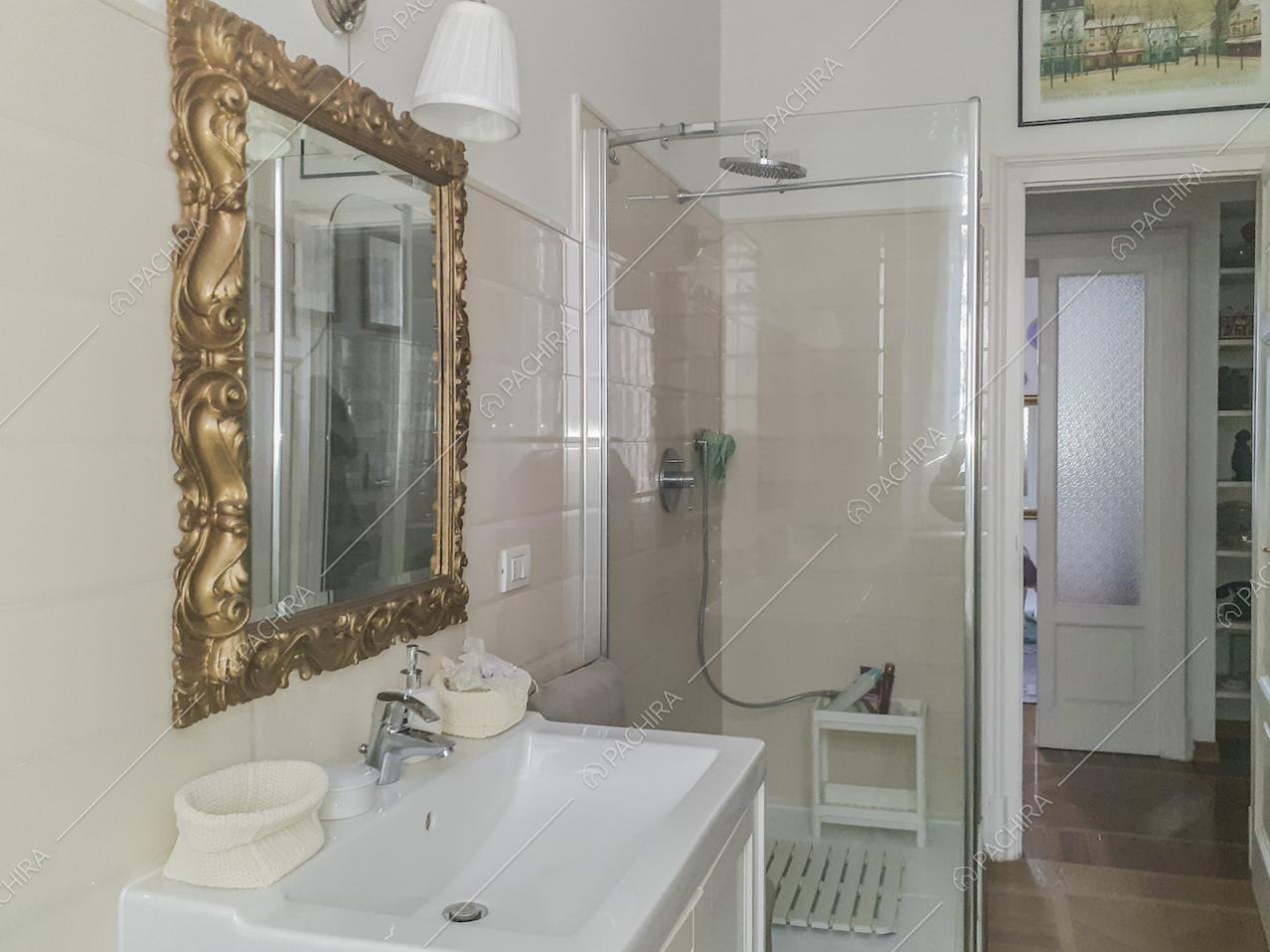 Specchio con cornice decorativa dorata e box doccia in vetro
