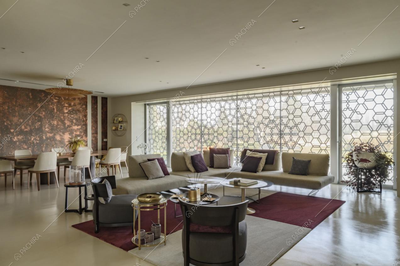 Luminoso salotto con divano angolare, pavimento in gres, carta da parati e lampadario di design