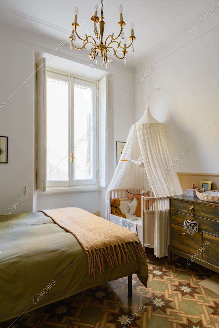Letto matrimoniale nella luminosa camera da letto con pareti bianche e vetrate