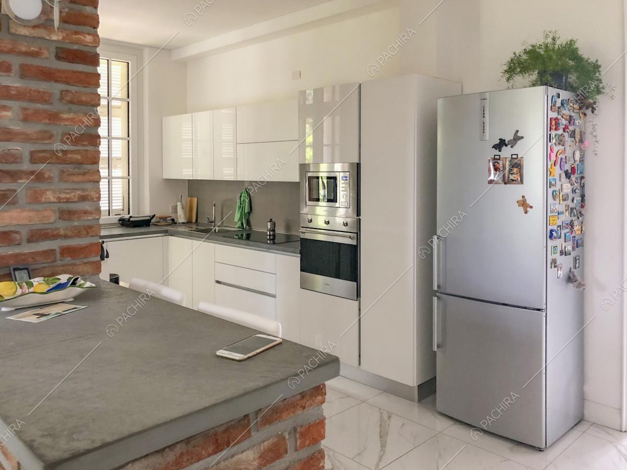 Mobili da cucina bianchi con elettrodomestici e frigorifero