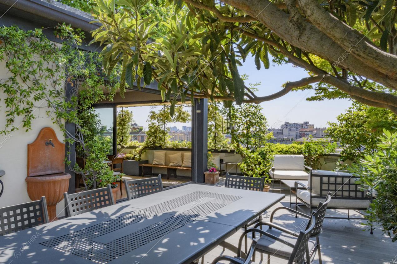 Dettaglio del tavolo da pranzo sotto alle piante del terrazzo