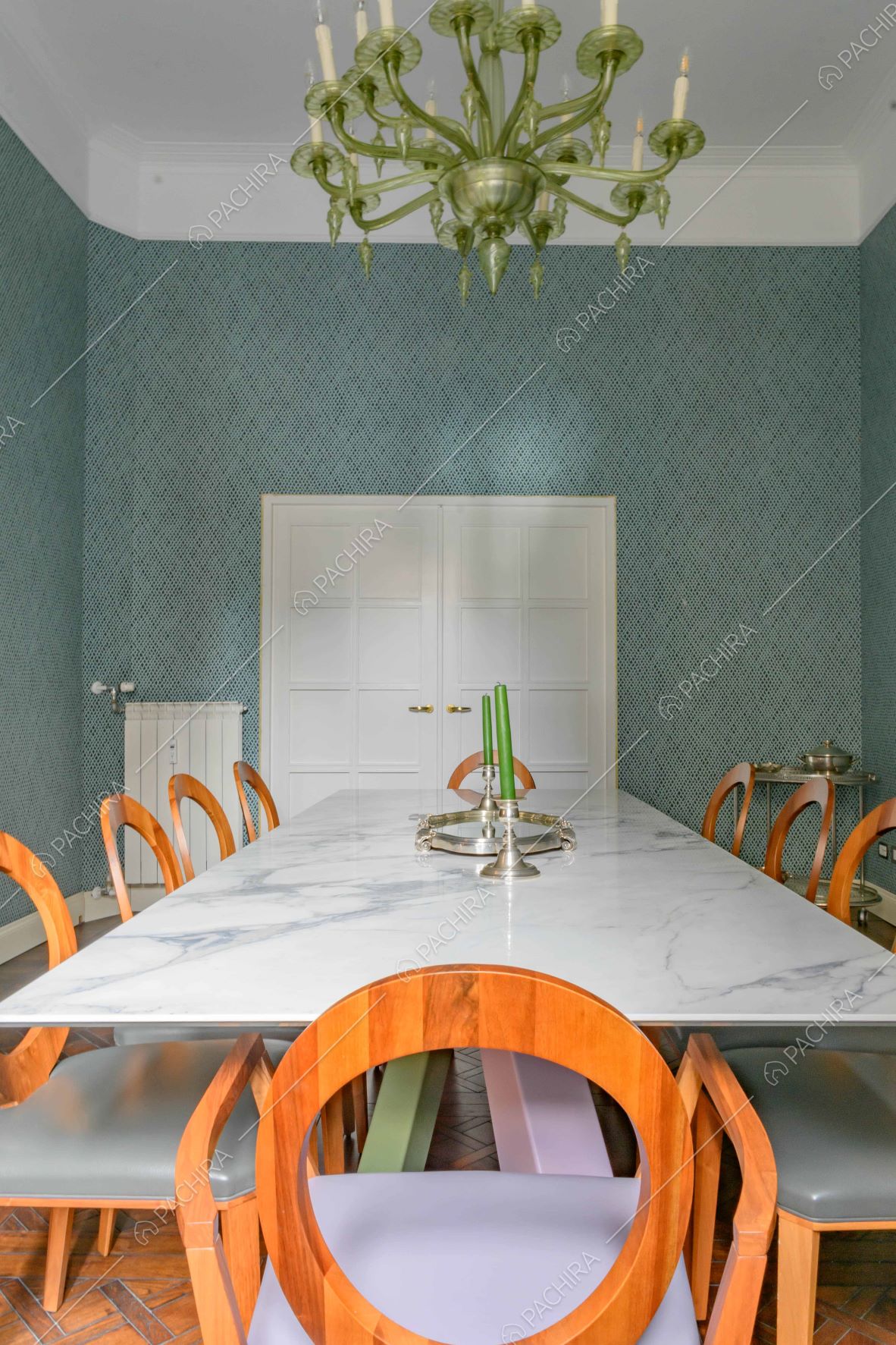 Sala da pranzo con tavolo in marmo, lampadario verde antico e boiserie sul soffitto