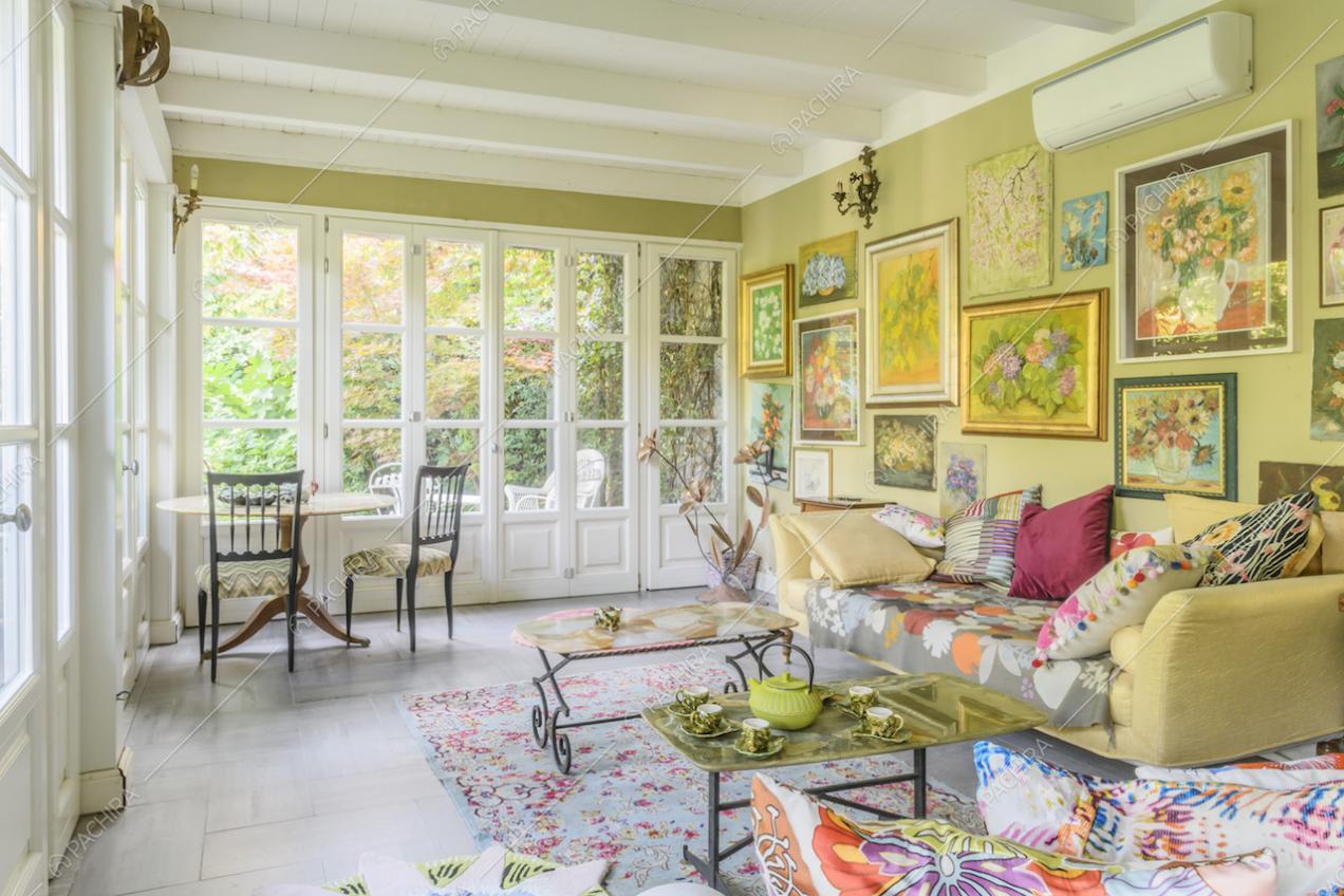 Tavolino e sedie vintage di fronte alle vetrate con vista sul giardino