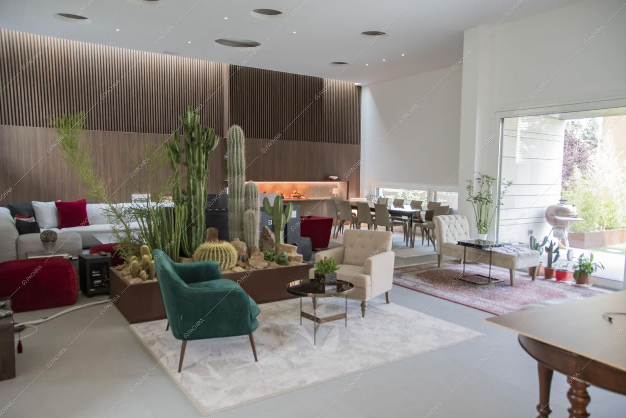 Ampia zona living con poltrone di varie tipologie e vetrata con vista sul giardino