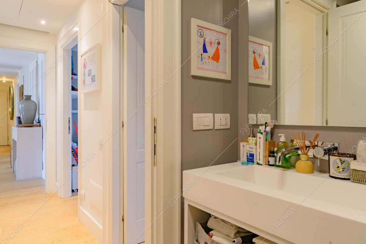 Parete grigia del bagno con boiserie alle pareti e pavimento in parquet