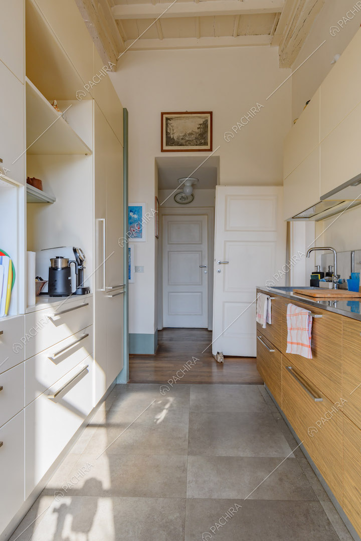 Pavimento in grandi piastrelle grigie nella cucina a parete con soffitto bianco a cassettoni