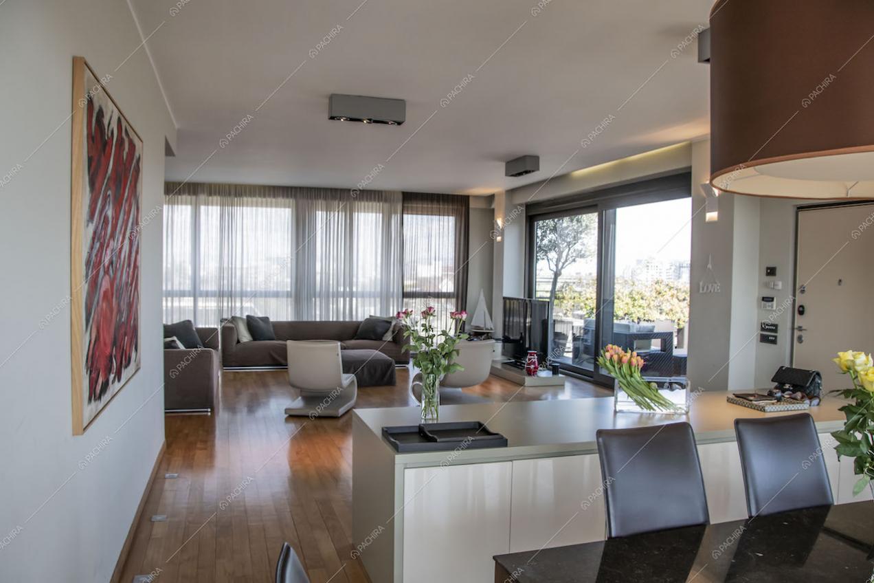 Dal tavolo da pranzo illuminato da lampade di design vista sul salotto