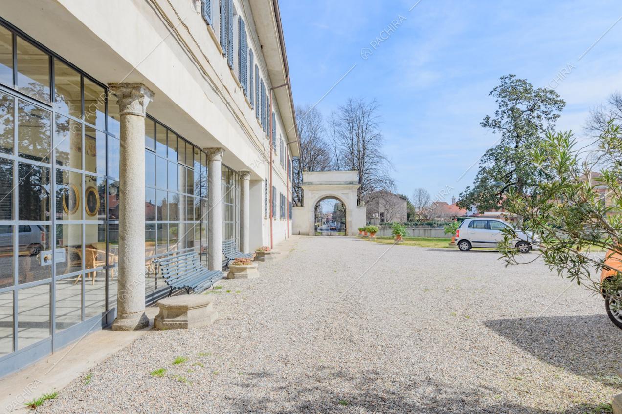 Dal cortile con pavimentazione in ciottoli vista sulle finestre in stile industriale della veranda