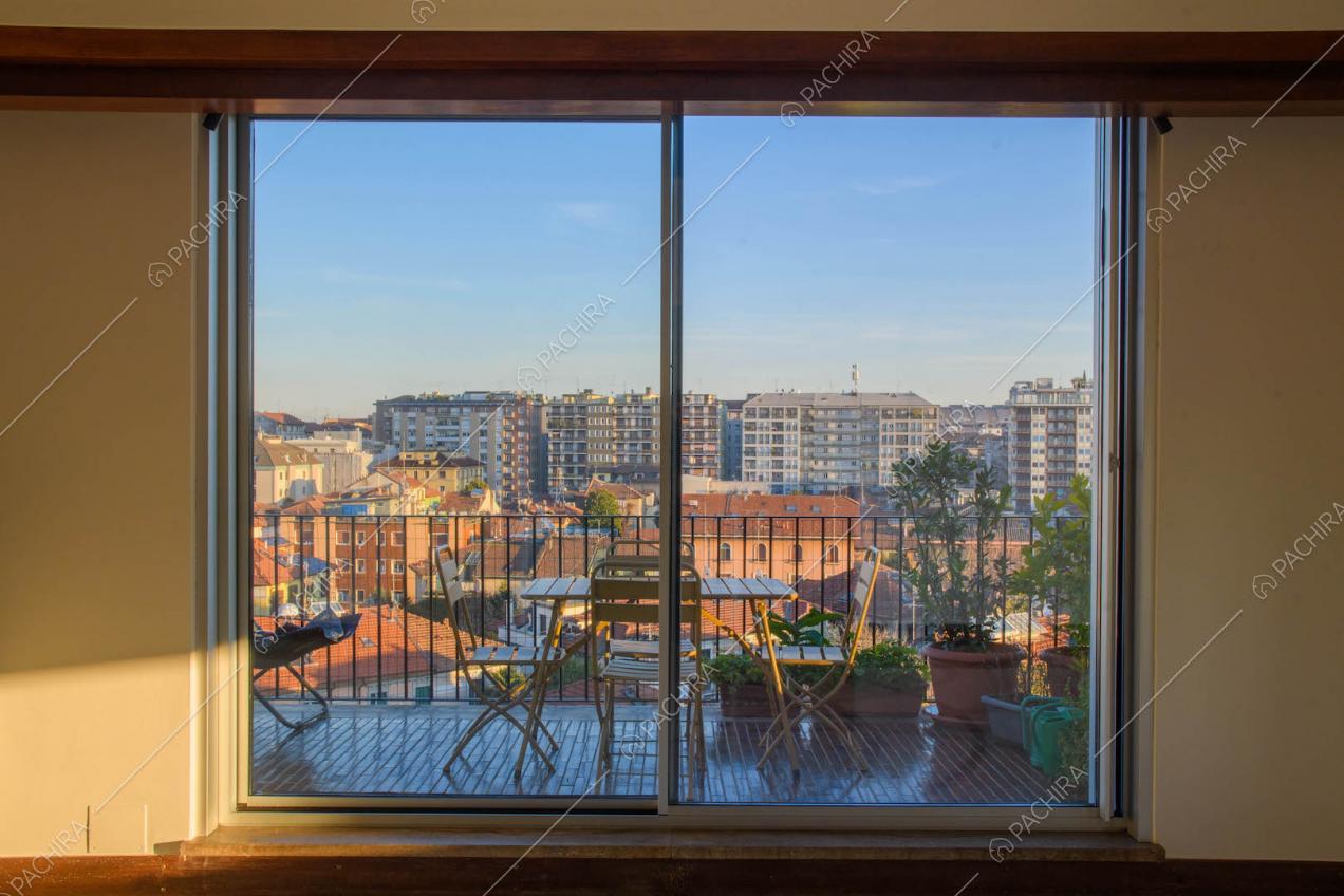 Porta-finestra scorrevole per accedere alla terrazza con tavolino e sedie da esterno
