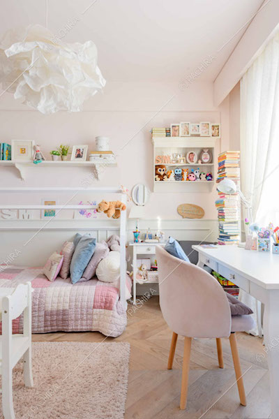 Luminosa camera da letto dei bambini con scrivania e pareti rosa