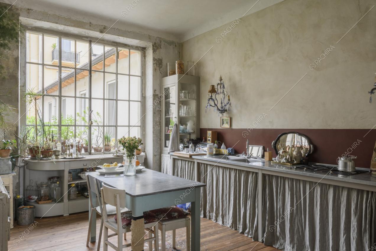 Cucina con mobili chiari e pareti con effetto délabré
