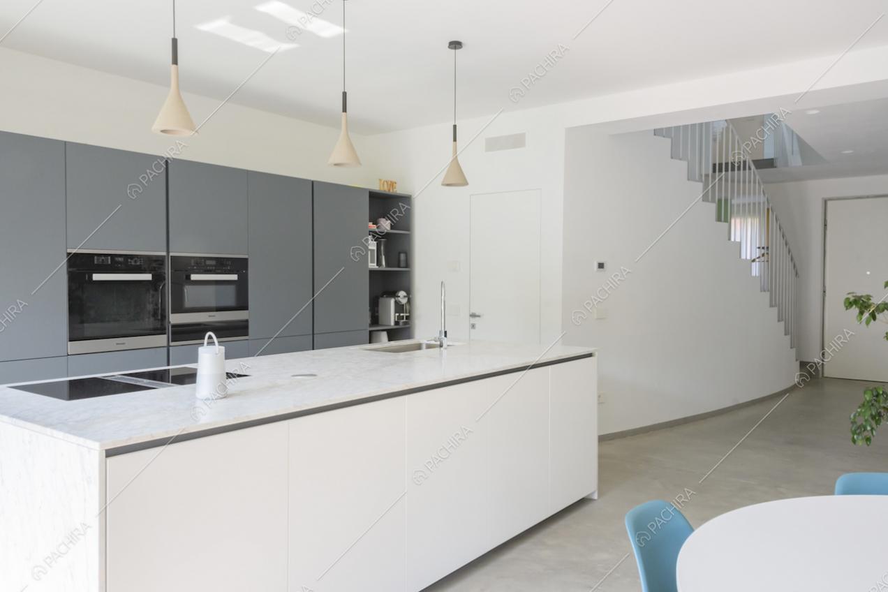 Cucina grigia e bianca con elettrodomestici e fornelli a induzione