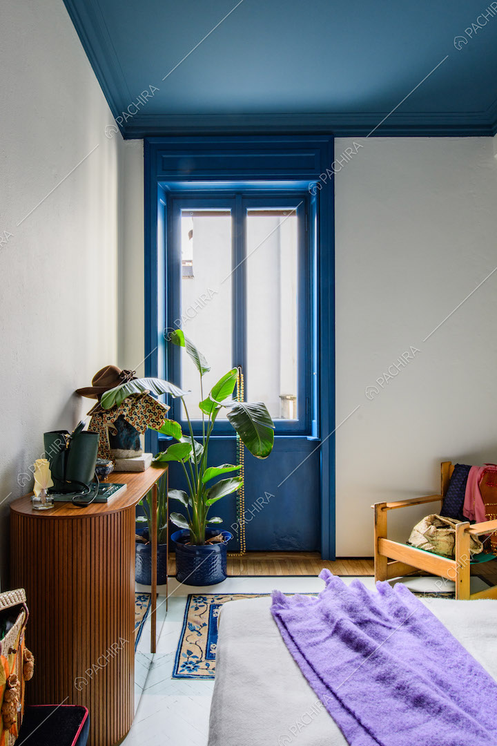 Porta-finestra e soffitto blu nella camera da letto matrimoniale con pavimento in parquet