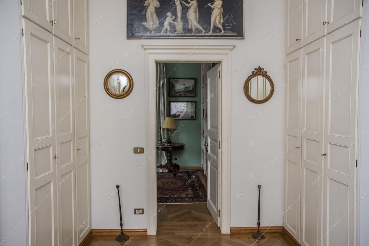 Pavimento in parquet, armadi bianchi a muro e vista sulla stanza