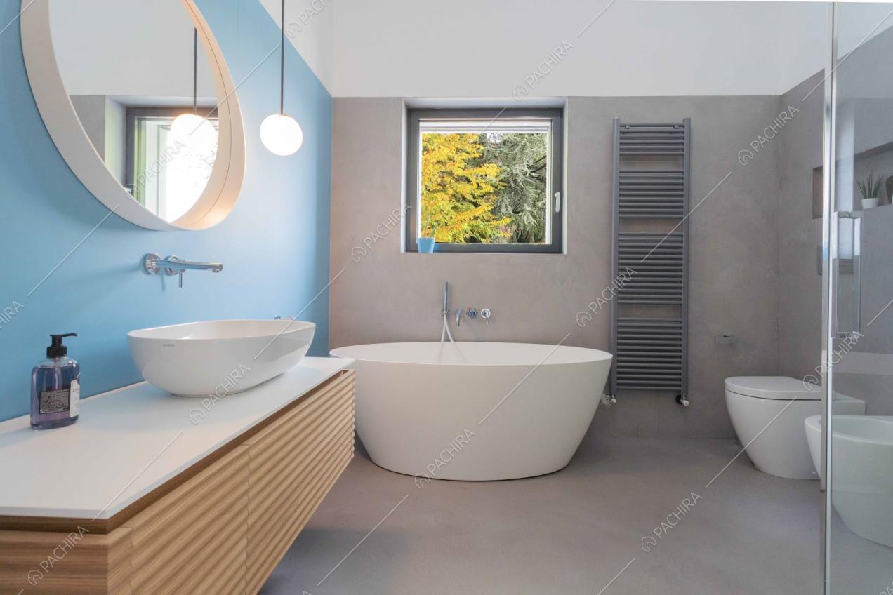 Ambio bagno con vasca bianca con pavimento e pareti grigie e blu