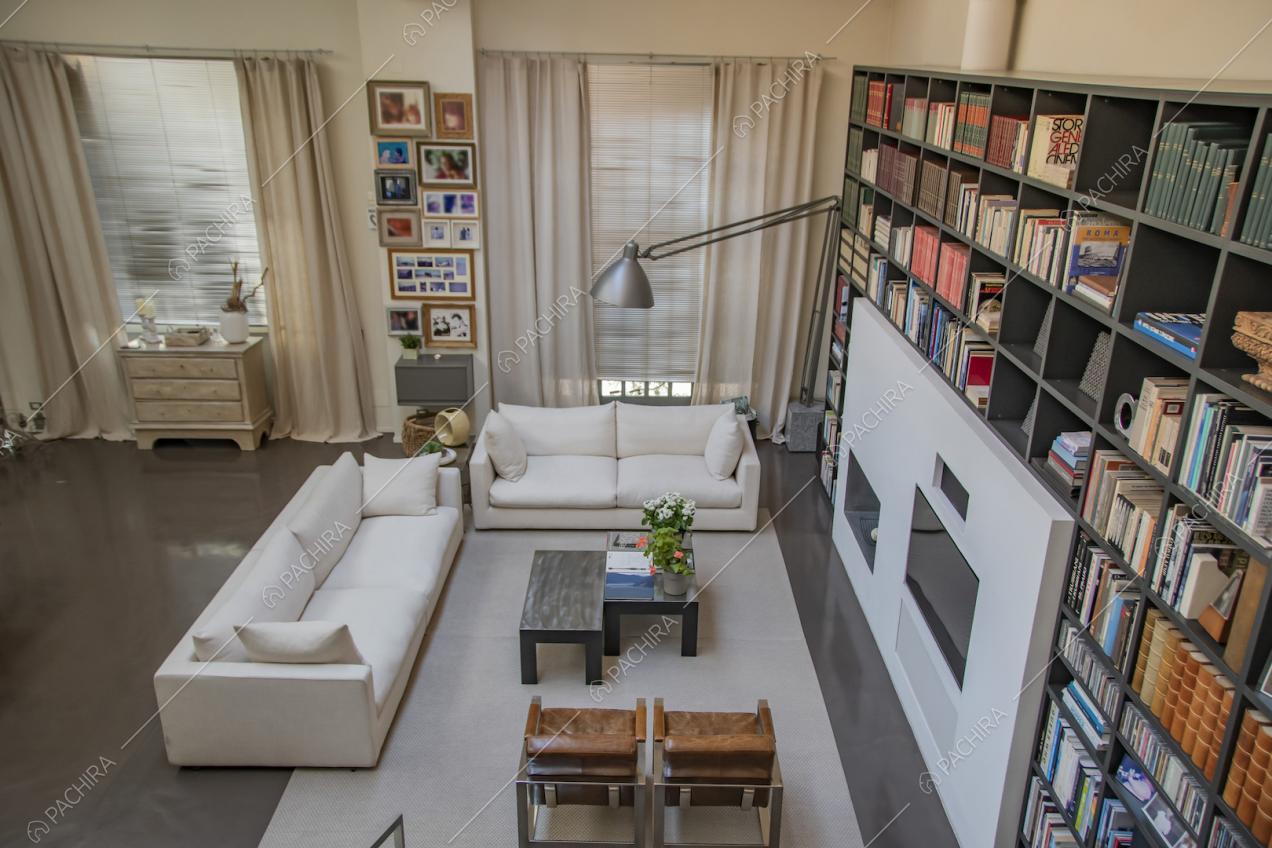 Grande tappeto sotto a divani e poltrone e libreria nell'angolo salotto