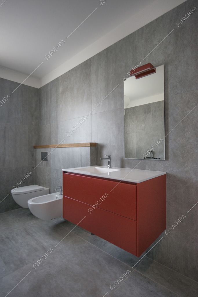 Bagno grigio con mobile del lavabo rosso e sospeso